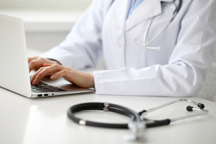 Doctor typing on a laptop